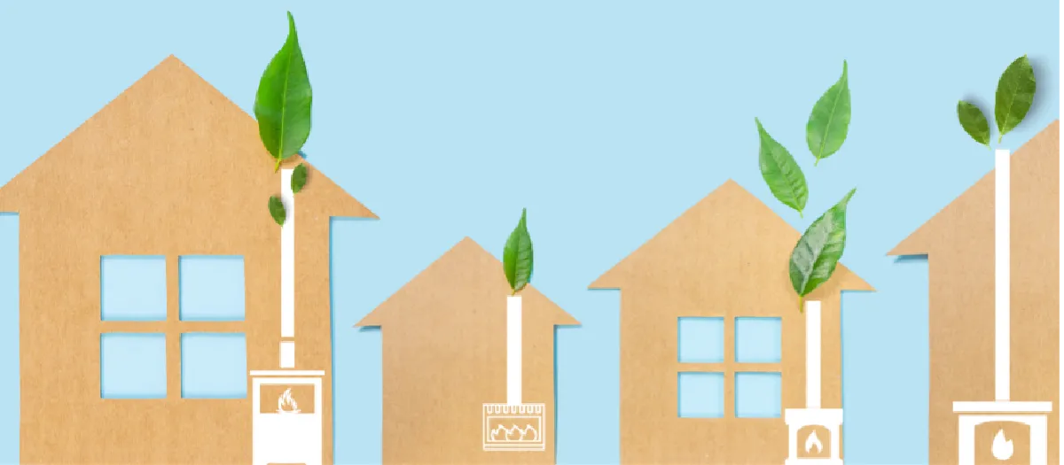 Cardboard cutouts of houses with drawings of stoves emit pipes growing green leaves, depicted against a light blue background.