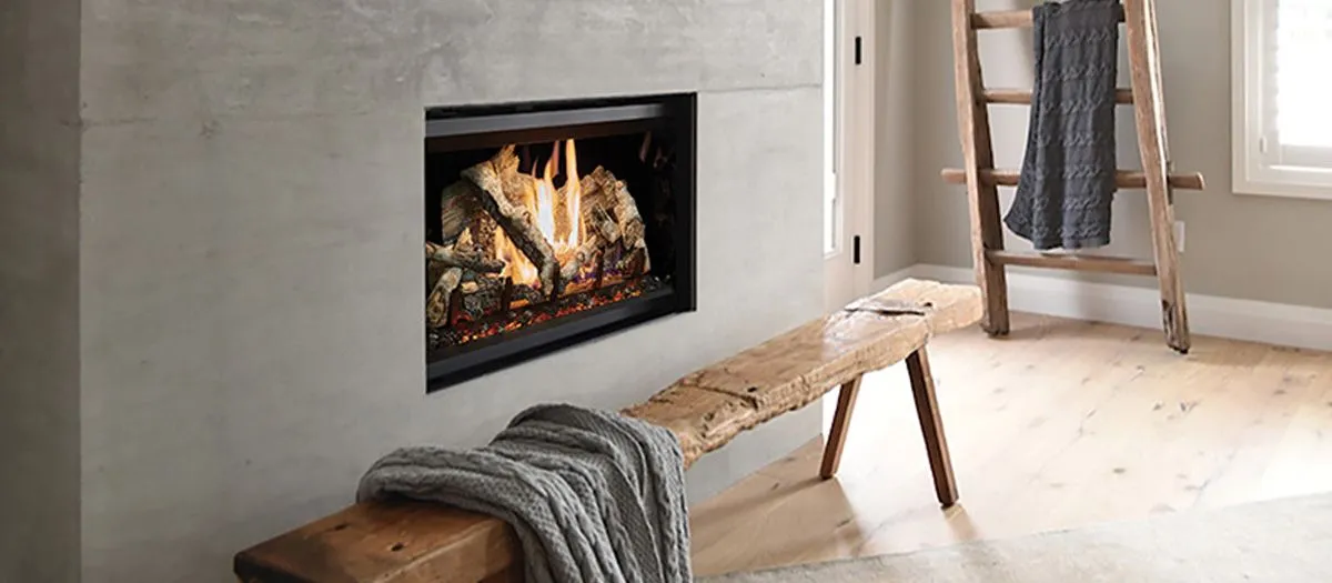 Modern living area with a built-in fireplace, rustic wooden bench draped with a gray throw, and a decorative ladder holding gray towels. Light wooden floor and partial window in the background.