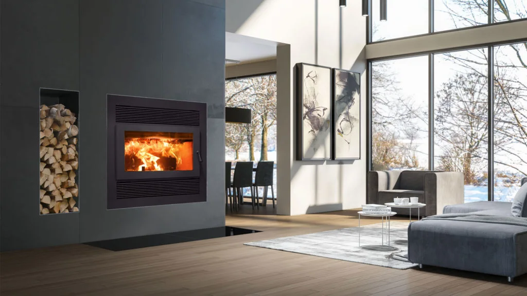 Contemporary living room with built-in wood-burning fireplace and log storage, floor-to-ceiling windows revealing snow-covered trees, gray sofa and dining area