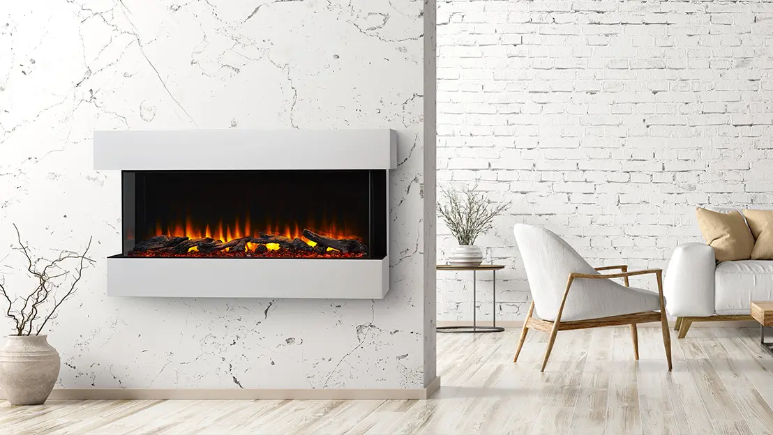 Modern living room with a white marble wall and mounted electric fireplace. Room features a white chair with wooden legs, a beige couch, a small side table, and a white brick back wall.