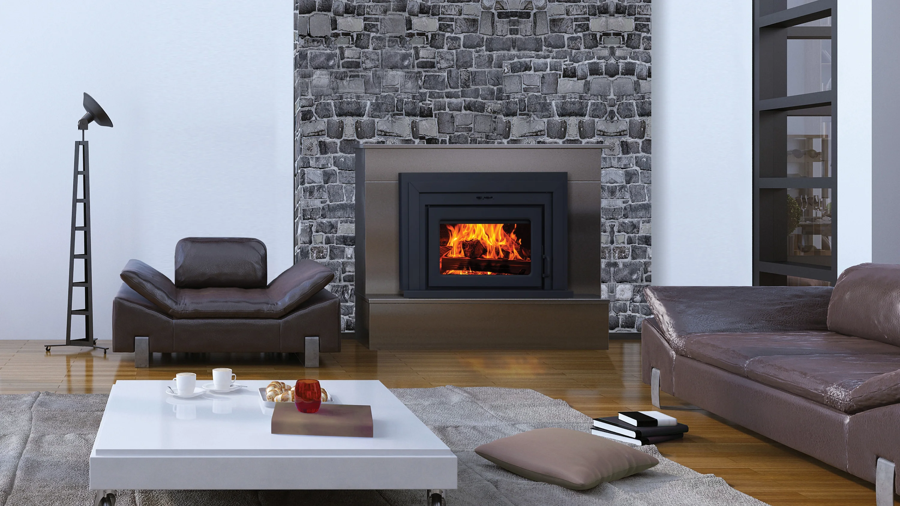 Modern living room with stone fireplace, fire burning, leather chair and sofa, white coffee table with cups, pastries, books, and a pillow on the floor, floor lamp in the corner.