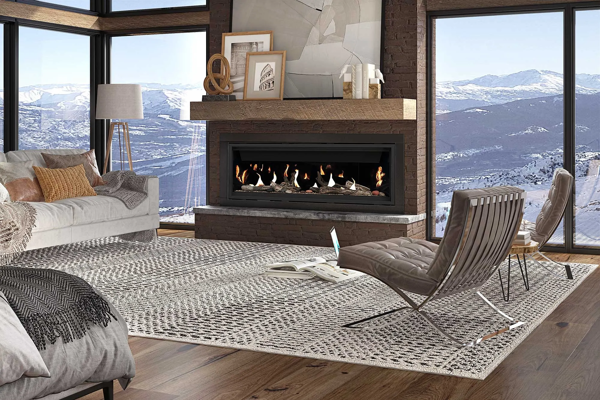 A modern living room with large windows showcasing snowy mountains. Features a fireplace, gray sofa, wooden floor, two contemporary chairs, and a textured area rug.