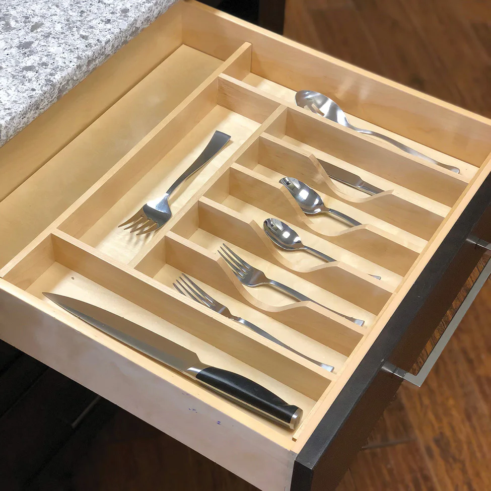 Open kitchen drawer with light wood cutlery organizer holding knife, forks, and spoons