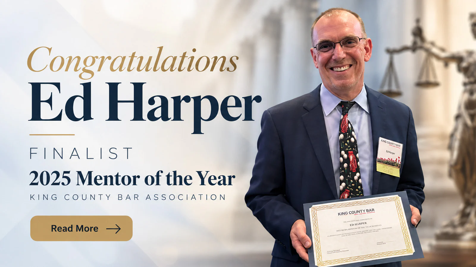 Smiling man in a suit holding a certificate beside a banner congratulating a 2025 Mentor of the Year finalist