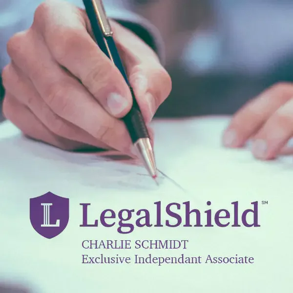 A person writing with a pen on paper. Below the hand is the LegalShield logo with text: 