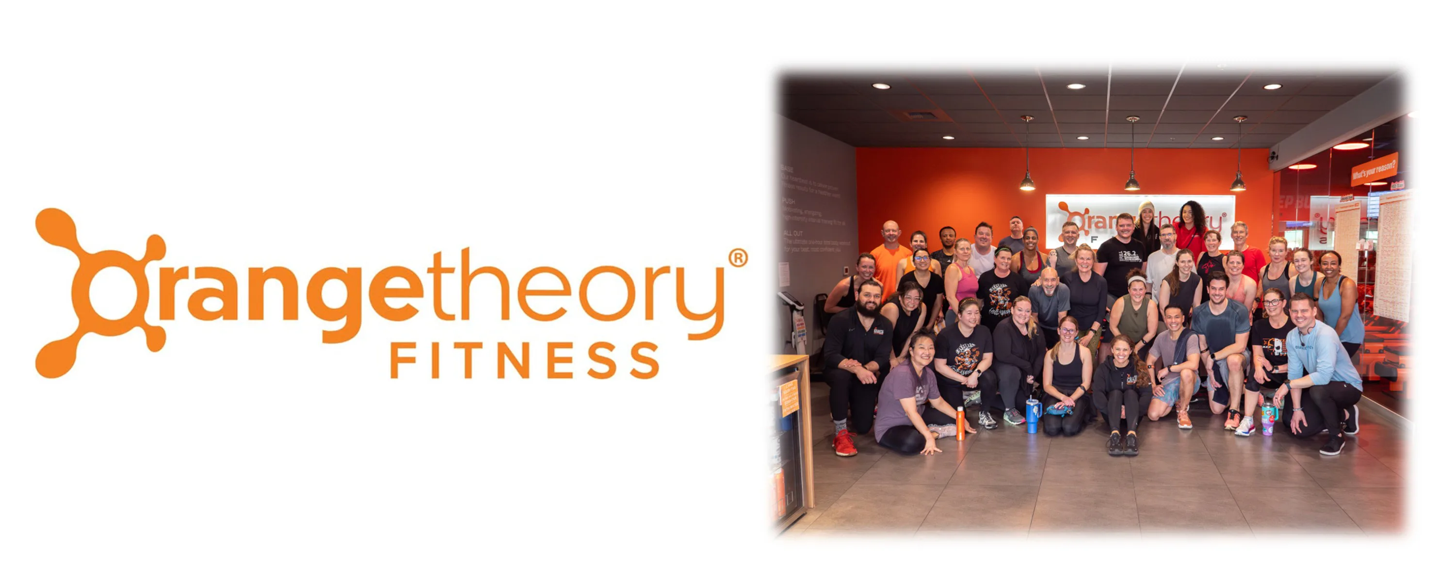 Orangetheory Fitness logo on left and a large group of smiling members and coaches posing inside an orange-walled studio with visible workout equipment