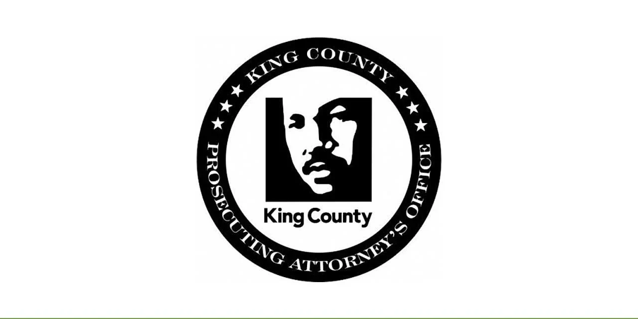 Circular black King County Prosecuting Attorney's Office seal featuring a stylized face portrait and the words King County