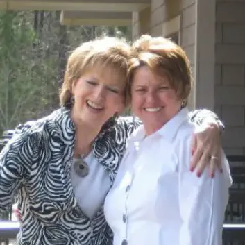 Two women with their arms around each other on a balcony